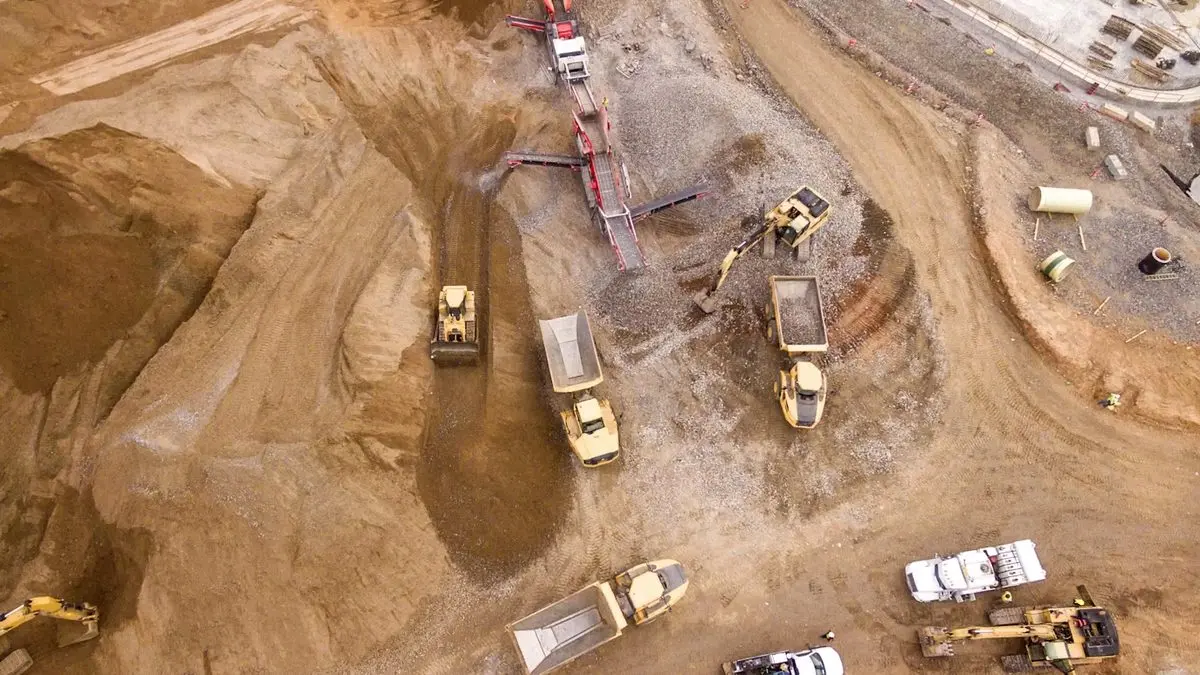 Vista aérea de uma frente de extração com dumpers e britador móvel